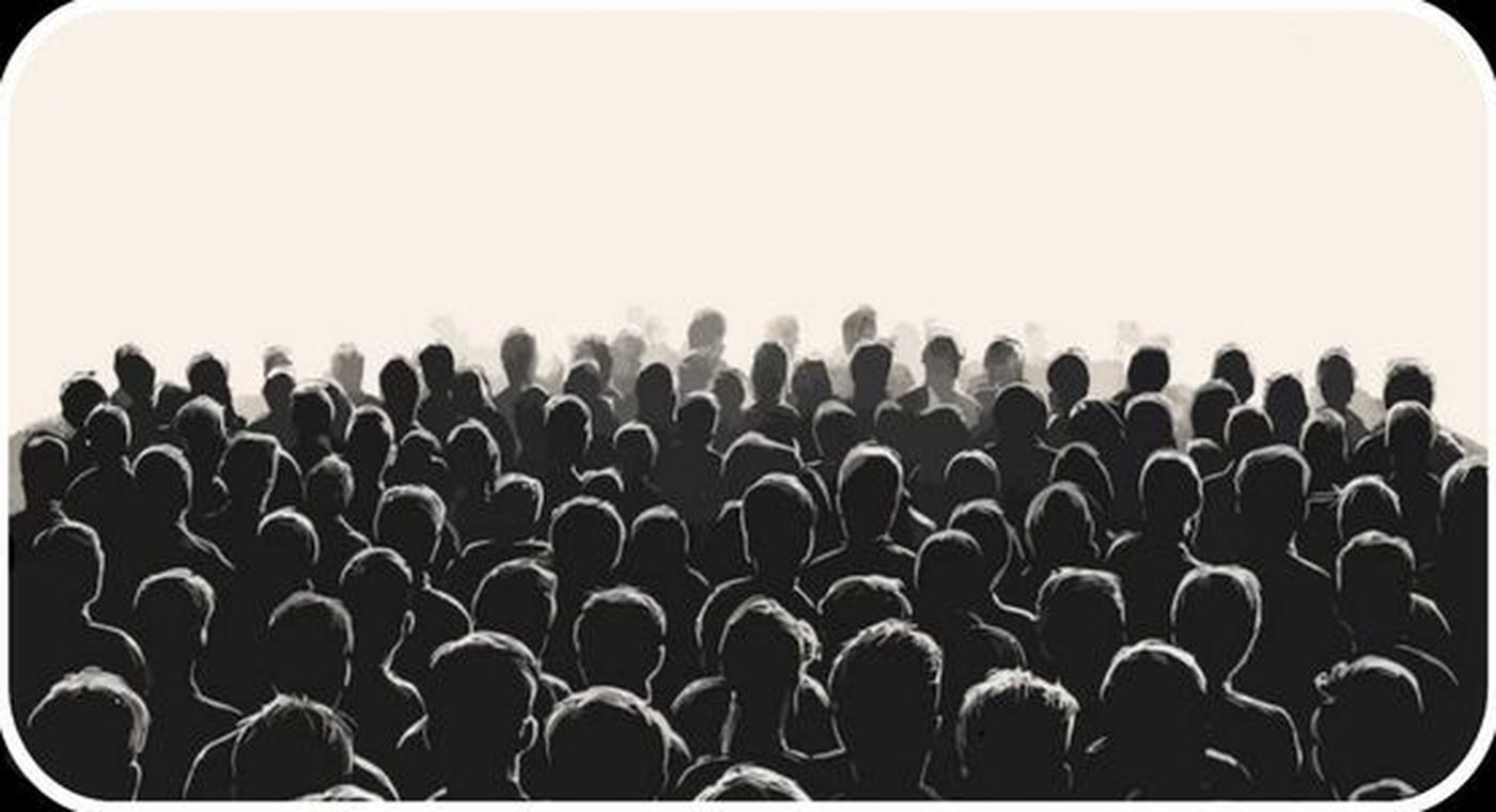 A crowd facing a bright screen